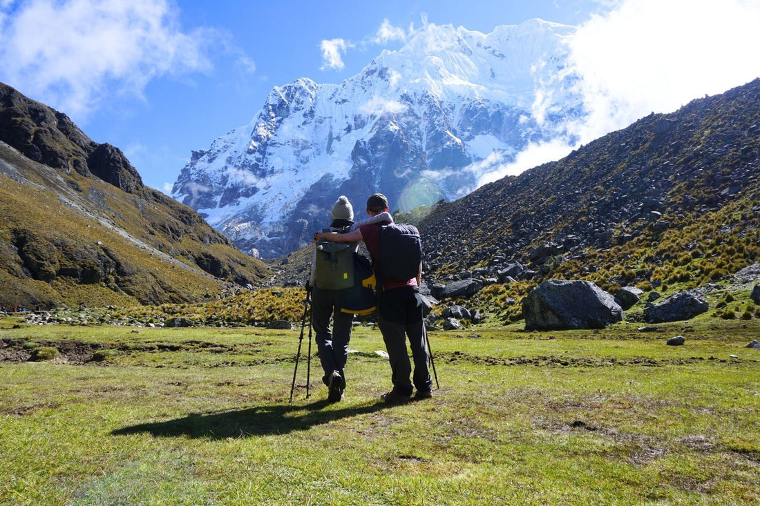 Trouvaille founders standing in a mountainous landscape with snow-capped peaks.