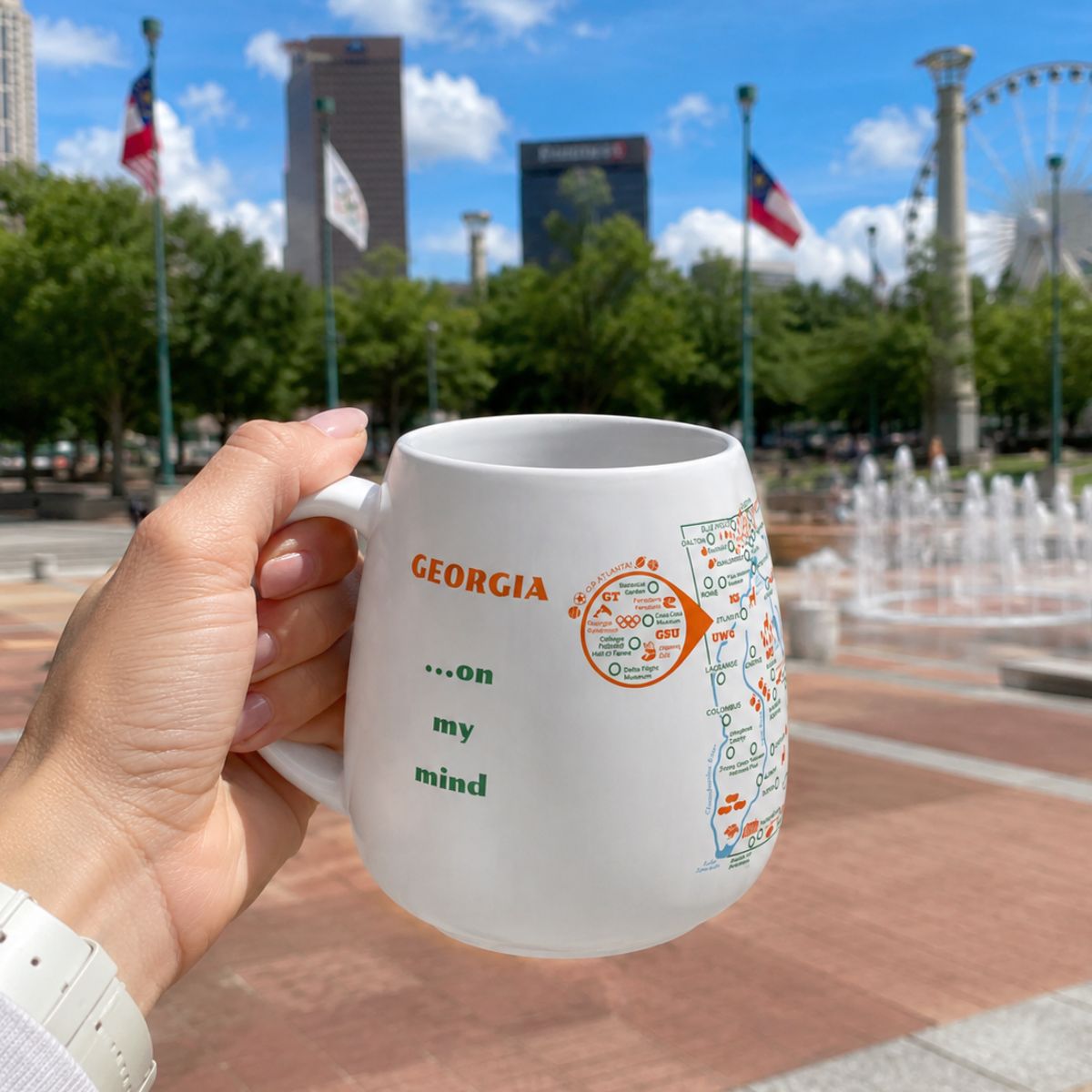 Person holding a Georgia color-in map mug in Atlanta Centennial Olympic Park