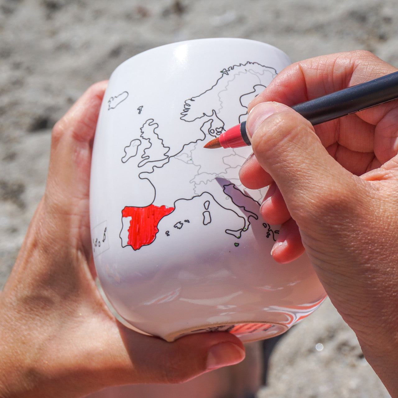 Colouring visited European countries on travel mug using red ceramic pen, customisable keepsake travel mug