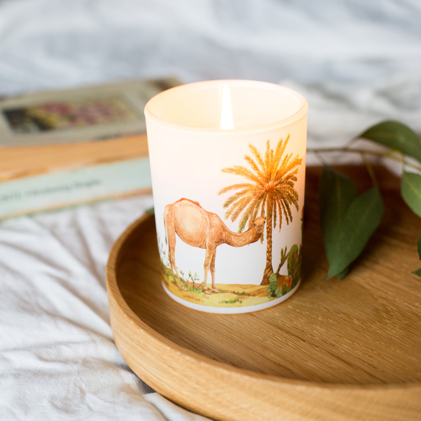 Lit Desert nature-inspired soy candle styled on a wooden tray, sustainable home fragrance inspired by warm desert landscapes.