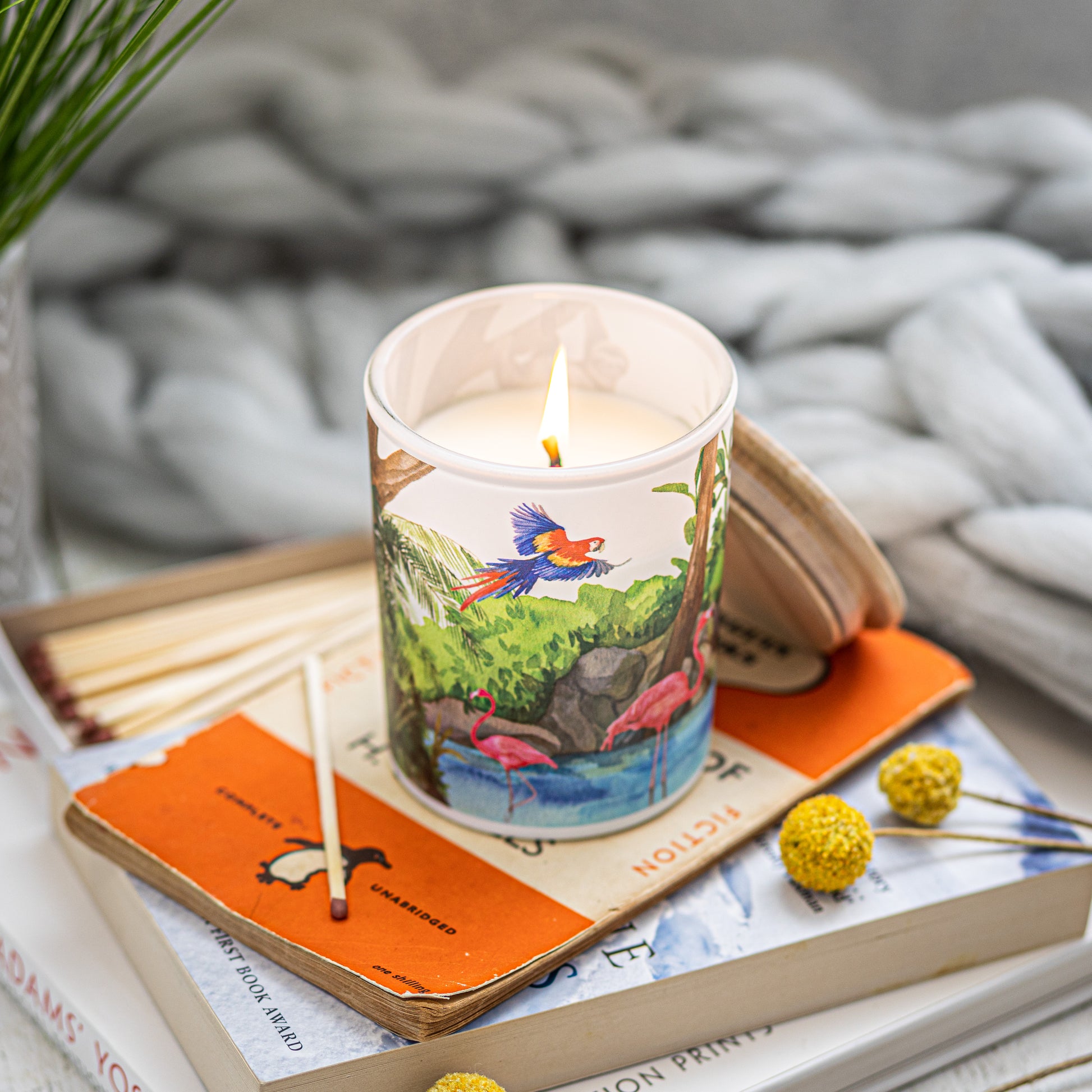 Lit Freshwater travel-inspired soy candle styled on books, sustainable eco-friendly gift for nature lovers.