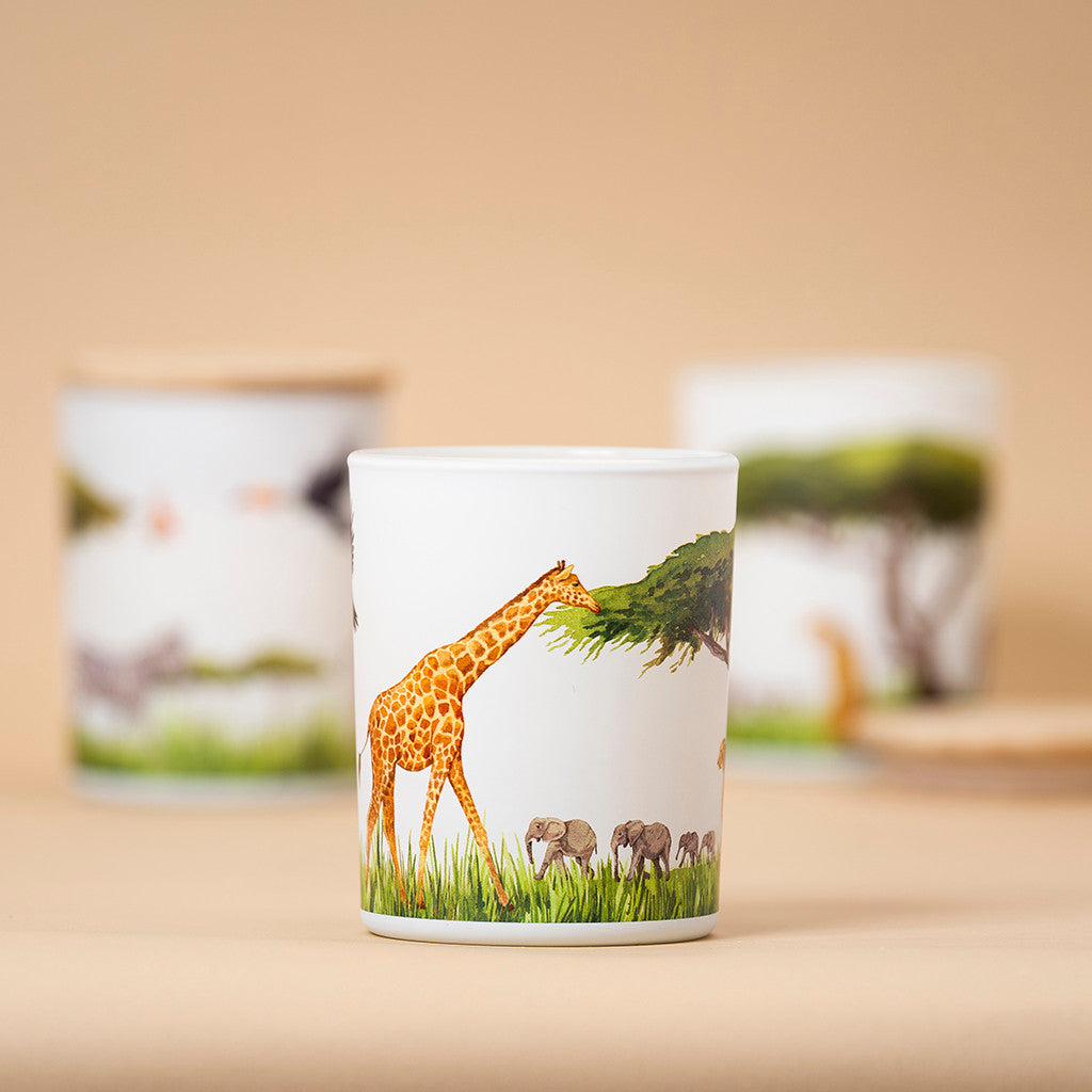 Grassland soy candle featuring a 360-degree wildlife illustration with a giraffe and elephants, inspired by the African savanna.