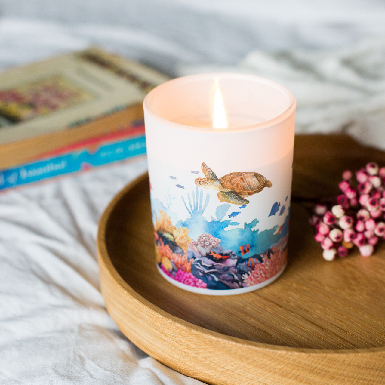 Lit Marine soy candle styled on a wooden tray, a refreshing sustainable home fragrance gift for mindful living.