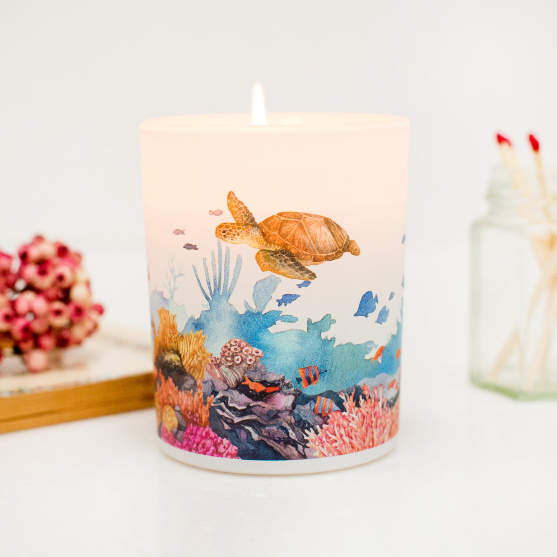 Lit Marine sustainable soy candle on a white background. A thoughtful eco-friendly gift for nature lovers.