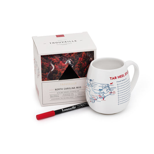A white ceramic travel mug with a map of North Carolina design, accompanied by a red ceramic pen and its packaging box.