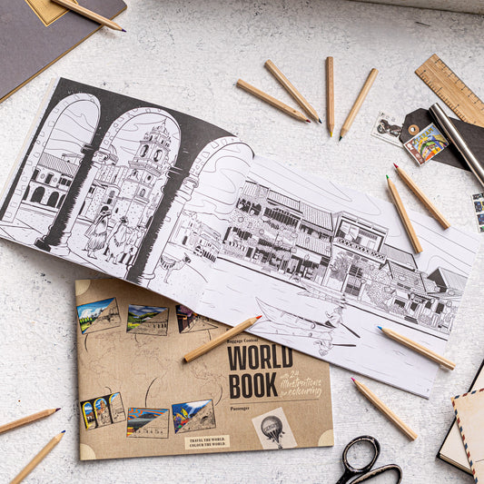100% recycled world travel colouring book opened with travel illustrations and pencils, sustainable colouring book for travel lovers.
