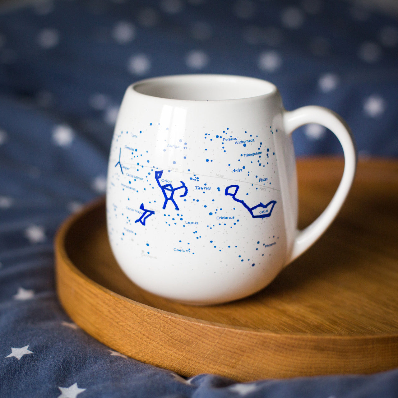 Stargazing constellation colour-in mug on wooden tray over starry duvet, astronomy gift for night sky lovers