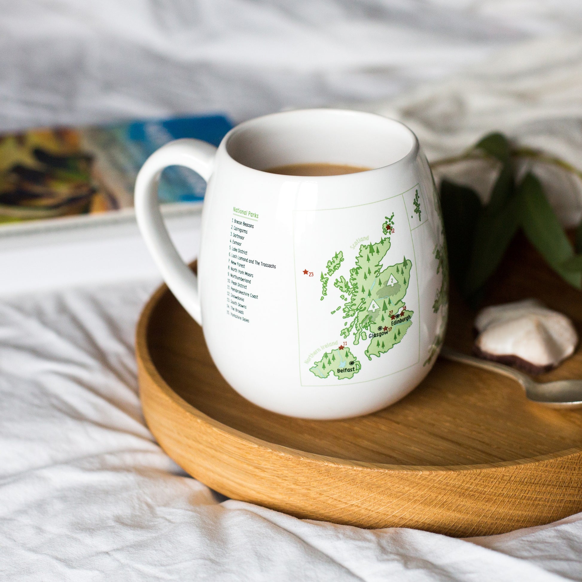 UK travel bucket list colour-in mug filled with coffee on breakfast tray with biscuit, plan UK adventures over a cuppa
