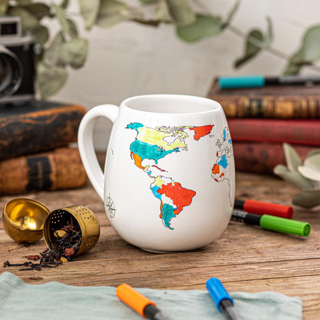 World map colour-in travel mug with countries coloured to track places visited surrounded by ceramic markers, unique travel memory gift